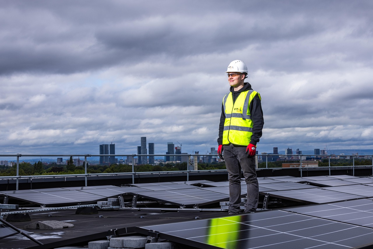 Solar installer standing beside panels on a DC-area rooftop